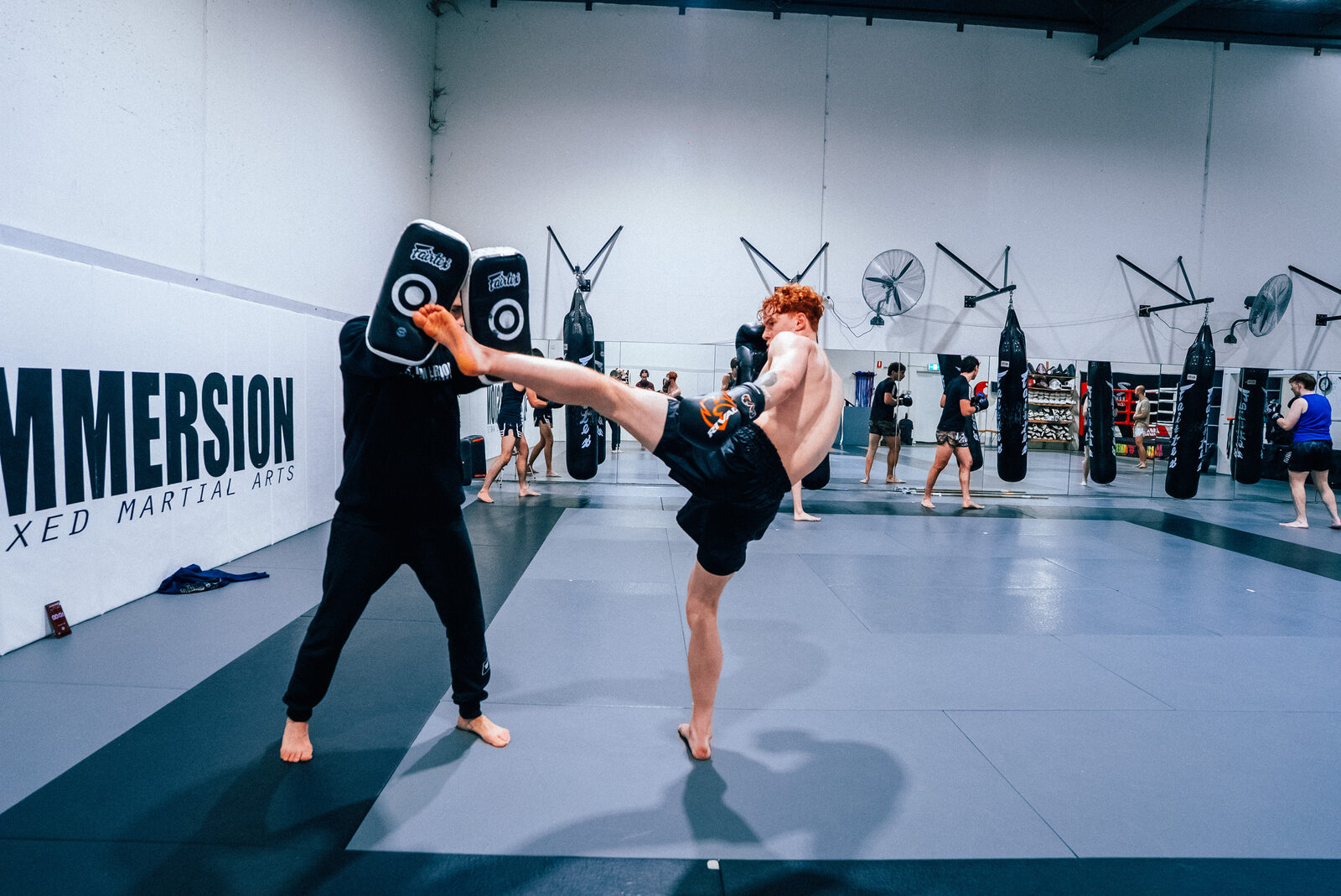 Student kicking to the body pads with the coach absorbing