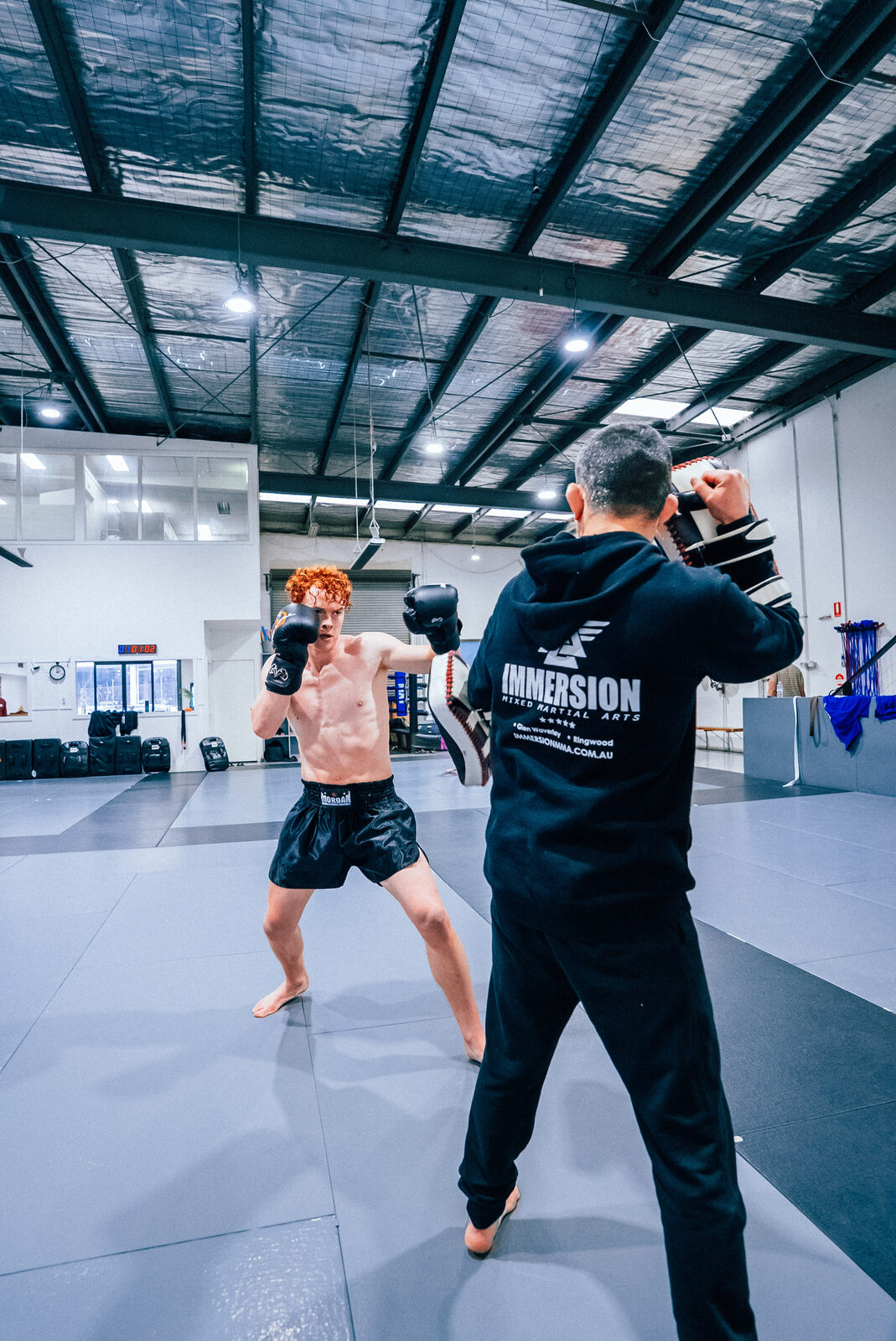 Student firing a straight punch into the pads
