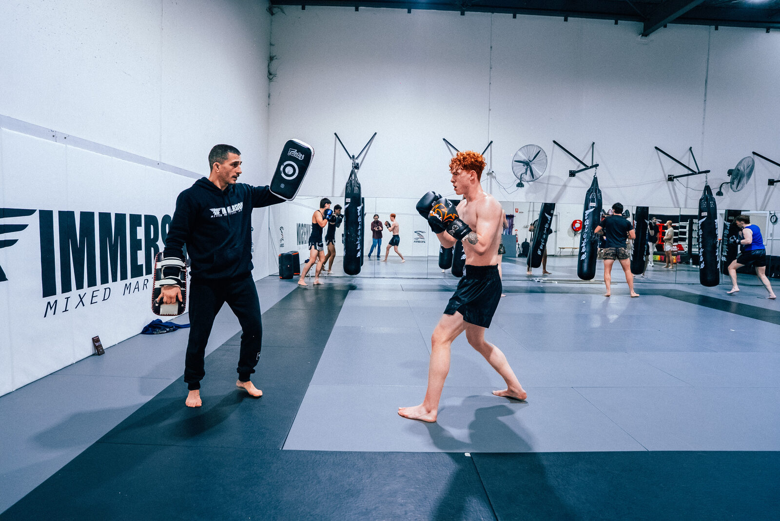 Coach and student squared up on the mats before a pad round
