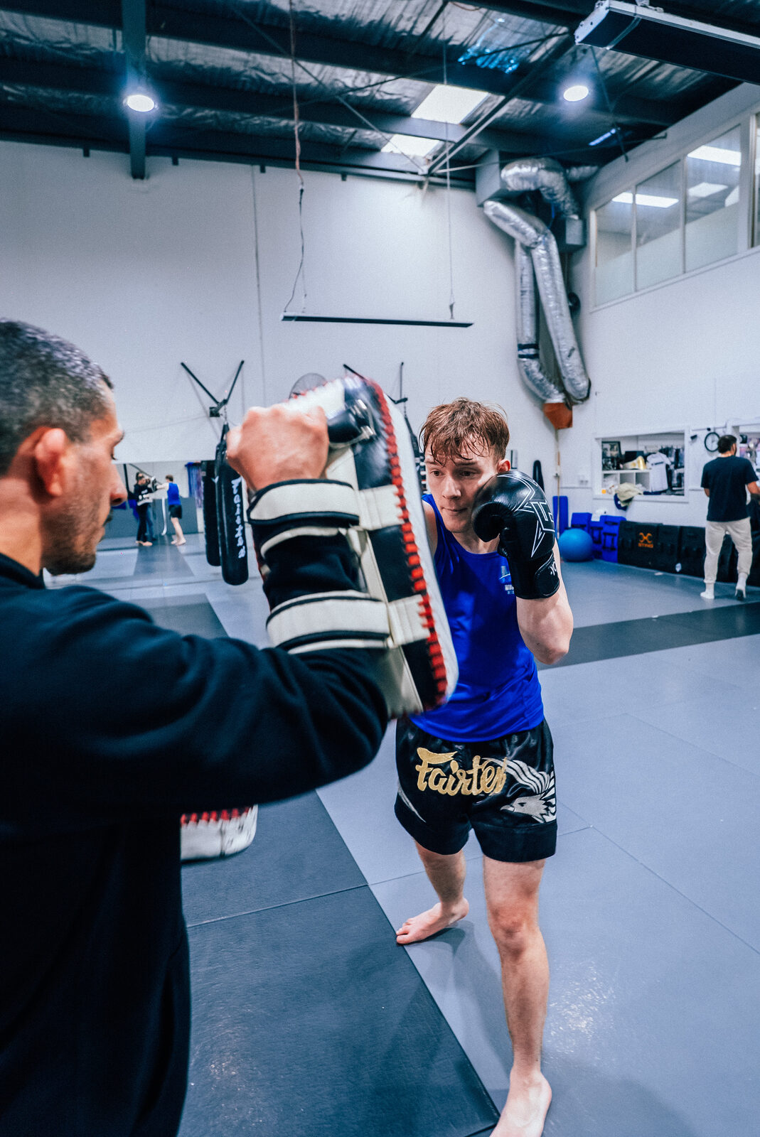 Student on the pads in a blue singlet